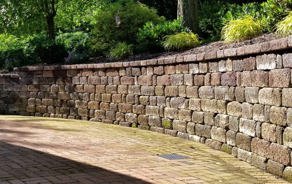 Retaining wall and patio with integrated drainage